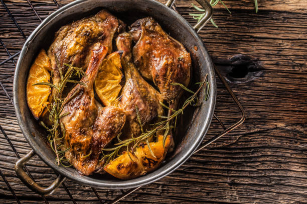 istock Roasted duck legs in pan with oranges herbs red cabbage and potato pankaces. 1059112678