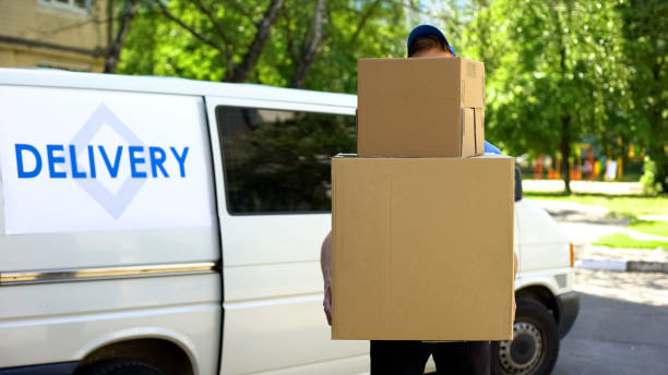 istock Delivery workman holding many cardboard boxes, express parcel shipment service 1059113182