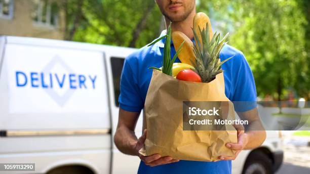 Food Delivery Service Male Worker Holding Grocery Bag Express Food Order Stock Photo - Download Image Now