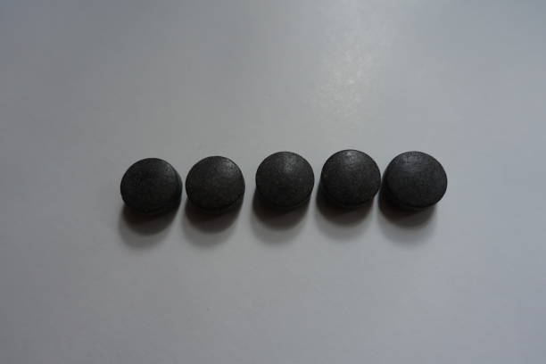 istock Row of five round black tablets of chelated iron 1059115808