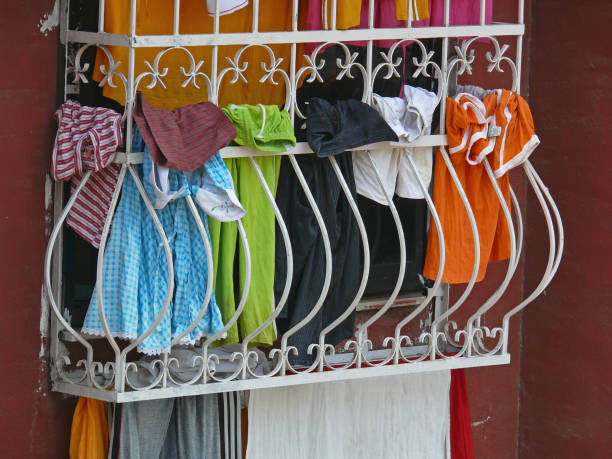 istock Cloths are hanging on clothesline outside a window 1059118324