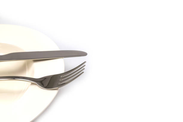 istock Stainless steel fork and knife on a white plate isolated 1059118618