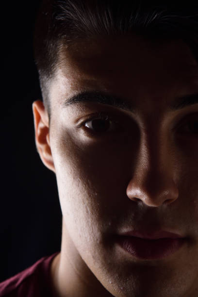istock portrait of a young man on black background 1059121176