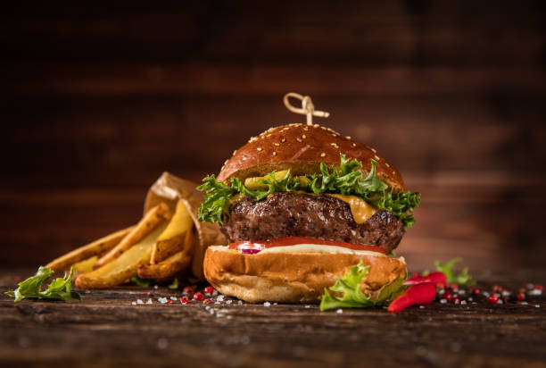 istock Delicious hamburger with fries, served on wood 1059121486