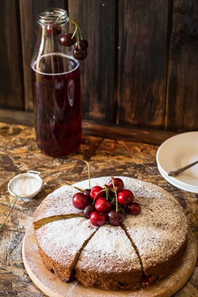 istock Viennese pie with cherry. Traditional cherry pie. Crostata witj berries. Stewed fruit in bottle. Sugar powder on cherry pie lying on wooden desk and wooden table. Homemade bakery. 1059122000
