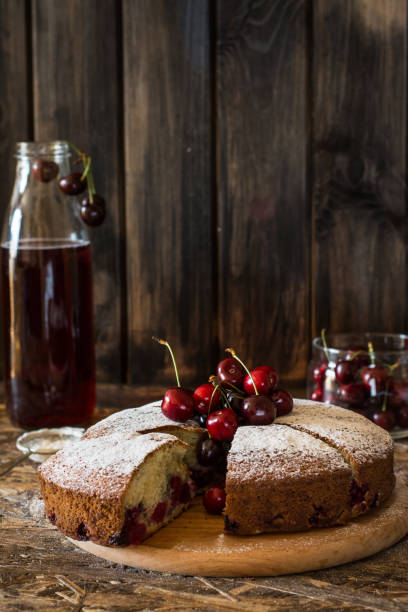 istock Viennese pie with cherry. Traditional cherry pie. Crostata witj berries. Stewed fruit in bottle. Sugar powder on cherry pie lying on wooden desk and wooden table. Homemade bakery. 1059122008
