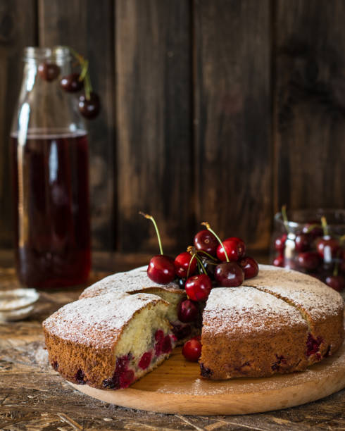 istock Viennese pie with cherry. Traditional cherry pie. Crostata witj berries. Stewed fruit in bottle. Sugar powder on cherry pie lying on wooden desk and wooden table. Homemade bakery. 1059122024