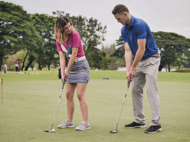 golfer seine freundin beizubringen, golf, lifestyle-konzept zu spielen. - golf green practicing sports training stock-fotos und bilder