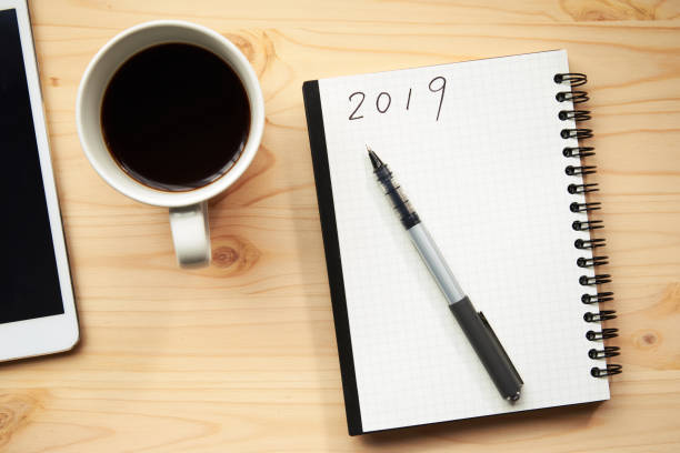 istock A cup of coffee and a notebook put on a wooden table 1059125330