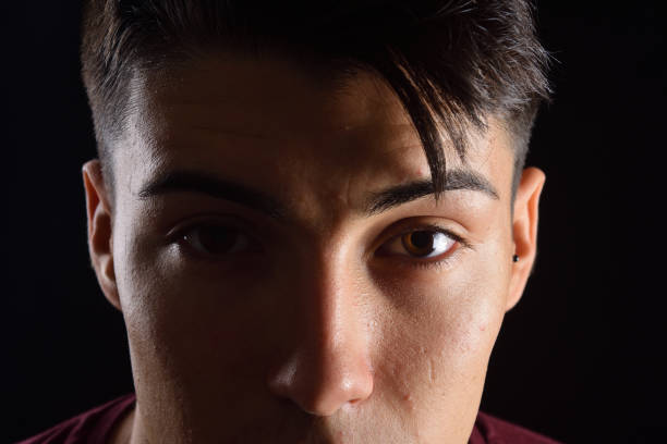 istock portrait of a young man on black background 1059125432