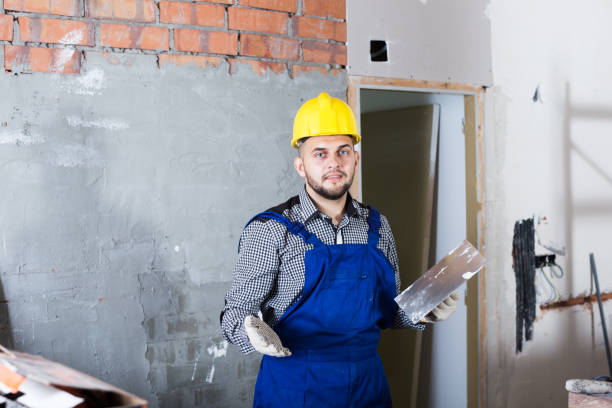 istock Builder in the helmet ready is plastering the wall 1059128874