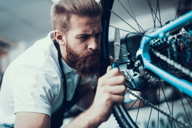 istock Bike Mechanic Repairs Bicycle in Workshop 1059130080
