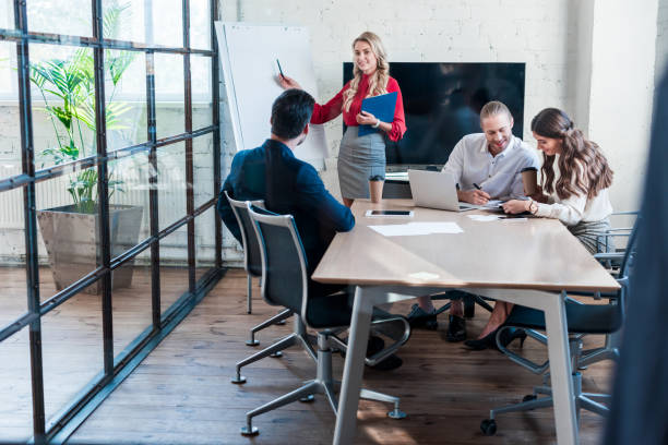 istock businesswoman pointing at empty white board during meeting in office 1059134580