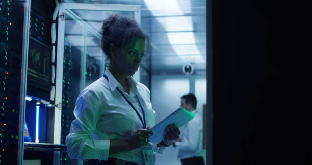 istock Black woman with tablet working in server room 1059137226