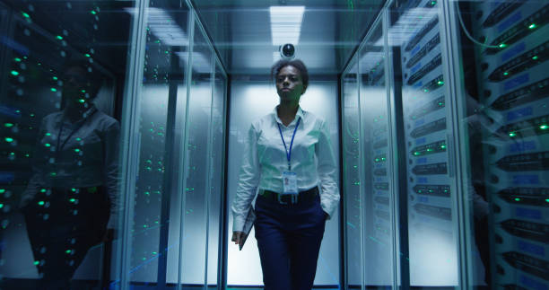 istock Woman walking among server racks 1059137258