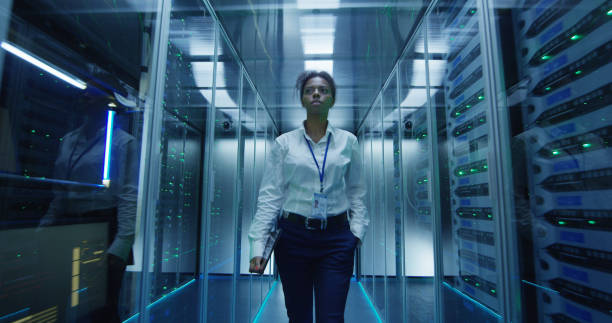 istock Woman walking among server racks 1059137262