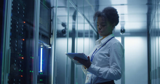 istock Black woman with tablet working in server room 1059137334