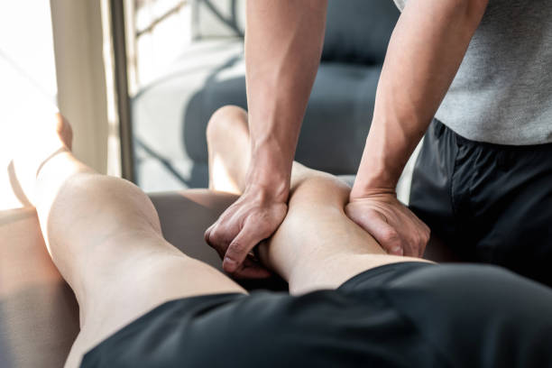 terapeuta masculino dando masaje de piernas y pantorrillas a paciente atleta - massage therapist massaging sport spa treatment fotografías e imágenes de stock