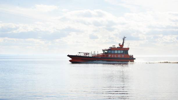 istock Red pilot ship sailing in still sea water on a sunny day 1059147366