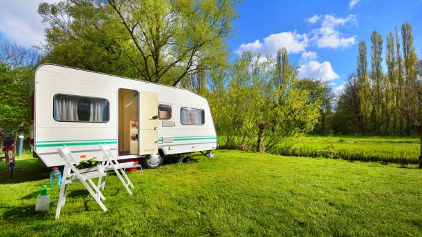istock Caravan trailer on a green lawn, on a sunny spring day 1059147400