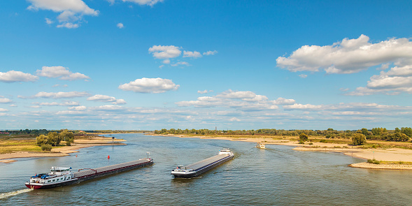 The Waal river near Nijmegen with cargo ships passing by in The Netherlands