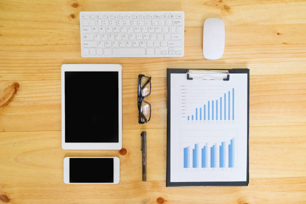 istock Office desk table with computer, supplies, analysis chart, calculator, pen and glasses . 1059149816