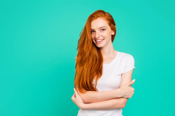 Portrait of gorgeous, nice, stunning, adorable, good-looking young girl in white polo with long hair hug herself and smile, stand isolated on pastel teal background with copy space for text Portrait of gorgeous, nice, stunning, adorable, good-looking young girl in white polo with long hair hug herself and smile, stand isolated on pastel teal background with copy space for text red hair stock pictures, royalty-free photos & images