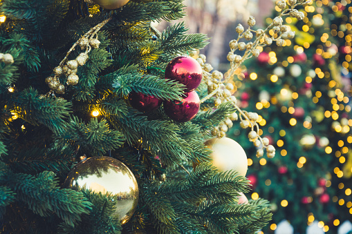 Details decorated Christmas tree with red balls, garland. Xmas card and pattern. Close up. Winter.