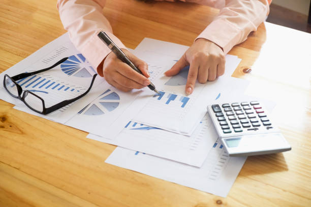 istock Business woman hand pointing at business document during discussion at meeting and  using a calculator to calculate the numbers. 1059150400
