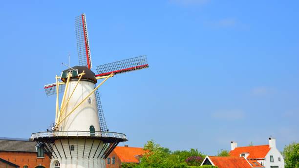 istock Classical Dutch landscape with a white windmill on a field against blue sky 1059155822