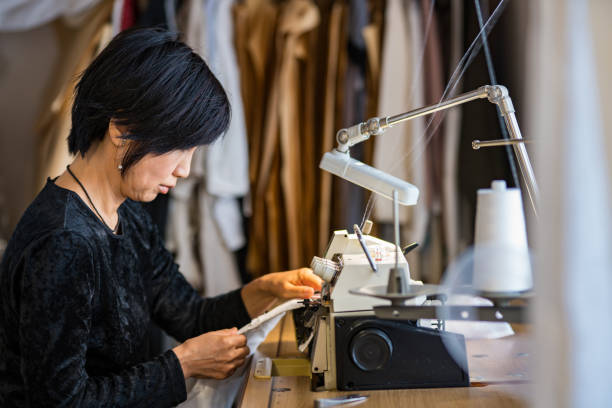 istock Mature woman using a sewing machine in her small textile studio 1059155836