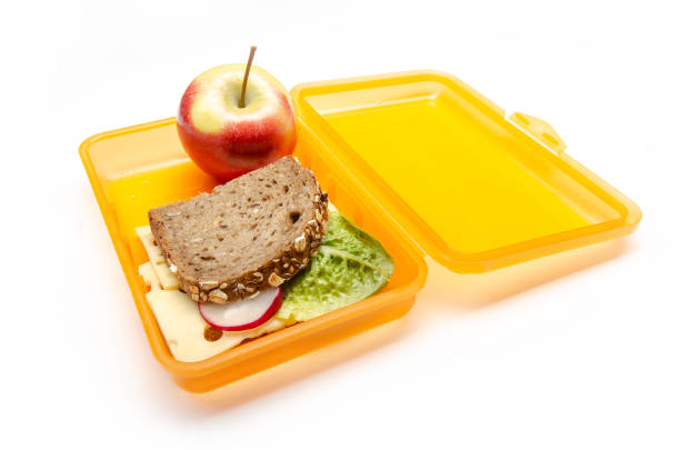 istock orange lunch box with bread and apple on white background, isolated 1059156306