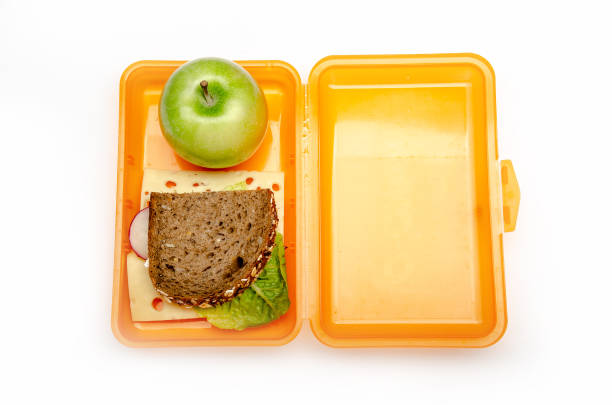 istock orange lunch box with bread and apple on white background, isolated 1059156342