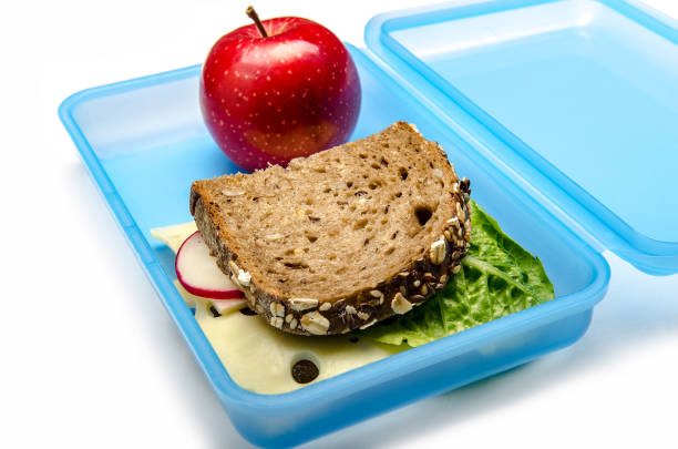 istock blue lunch box with bread and apple on white background, isolated 1059156496