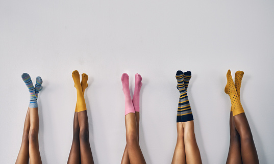 Cropped studio shot of a group of women’s legs in a row wearing socks