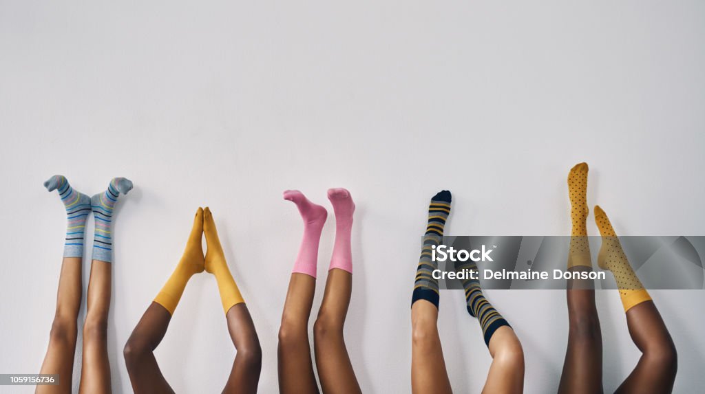 Socks, a fashion staple Cropped studio shot of a group of women’s legs in a row wearing socks Sock Stock Photo