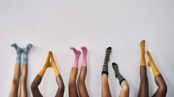 Cropped studio shot of a group of women’s legs in a row wearing socks