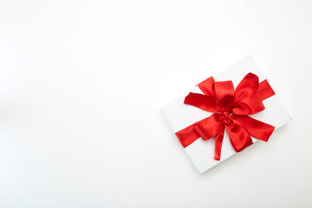 istock Christmas present in white wrapping paper and red ribbons 1059159206