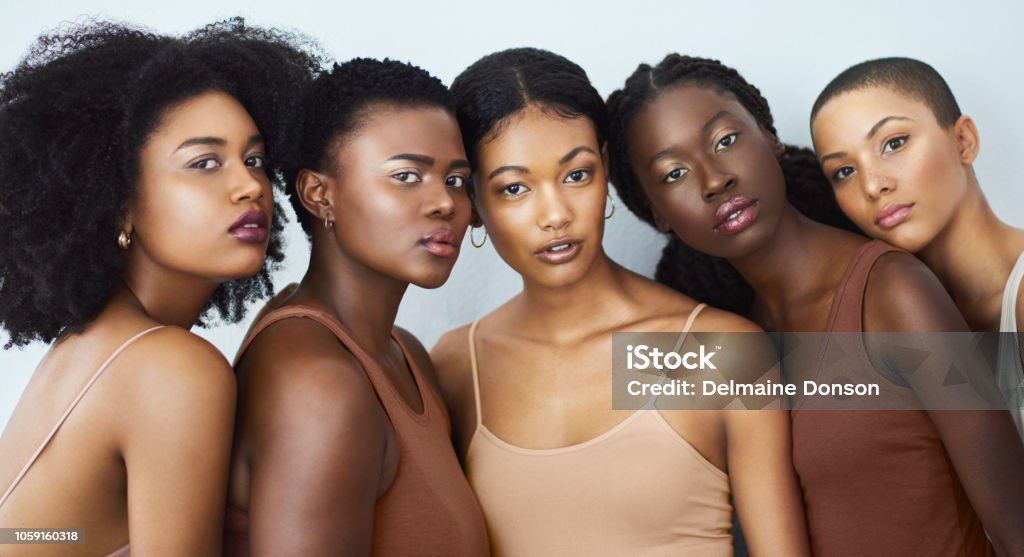 We're all born beautiful Studio shot of a group of beautiful young women posing together against a gray background African Ethnicity Stock Photo