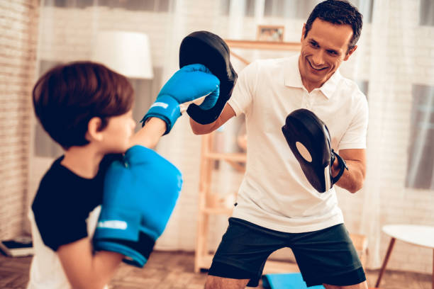 boy in boxing gloves and man trainer in apartment. - healthy lifestyle men boxing dumbbell imagens e fotografias de stock