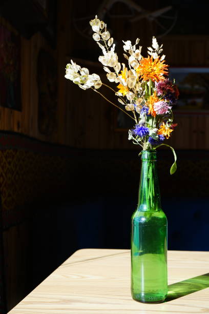 istock Home decorative flower bunch in green bottle on window morning light, copy space 1059162966