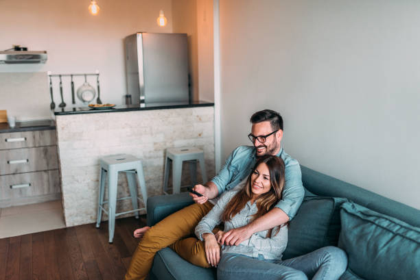 istock Young couple watching television at home. 1059163270