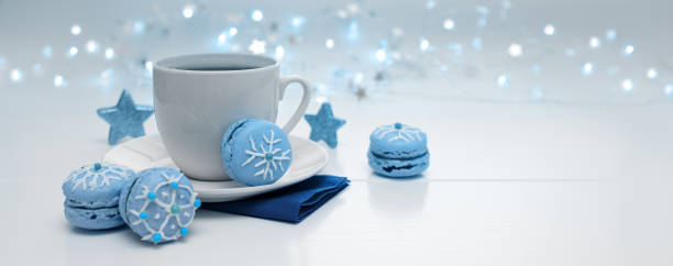 Christmas blue macaroons and coffee cup on gray background. Top view with copy space.