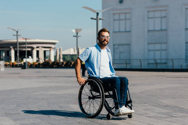istock smiling disabled handsome man in sunglasses using wheelchair on street 1059163320