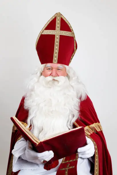 Saint Nicholas looks at you over his big book with a smile