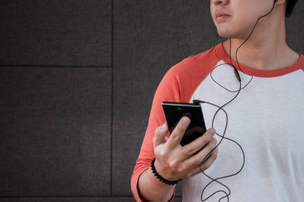 A man listening music on his smartphone, Hand holing mobile phone