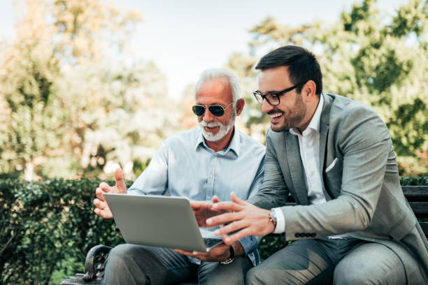 istock Two handsome man sitting on the bench and looking at laptop. 1059170336