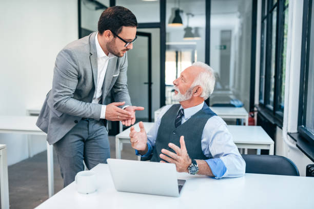 istock Senior and young man discussing at work. 1059171068