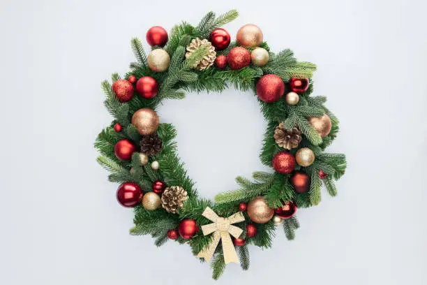 top view of decorative festive wreath with red and golden christmas toys isolated on white