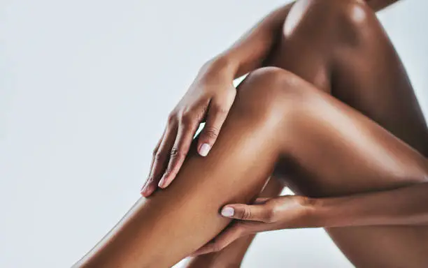 Cropped shot of a young woman caressing her legs